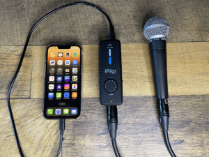 The image is of an iphone connected to the iRig Pro and a Shure SM58 microphone. It's designed to show people how the connection looks and how the device works.